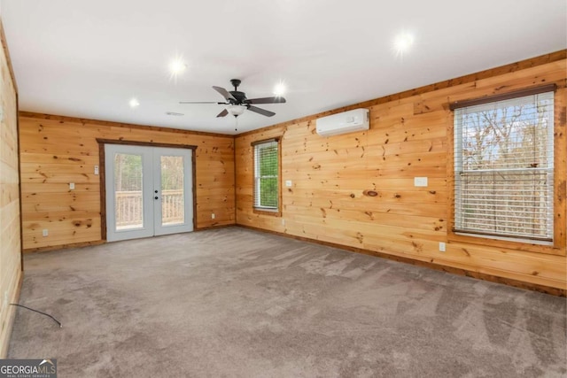 unfurnished room with carpet, wooden walls, and french doors