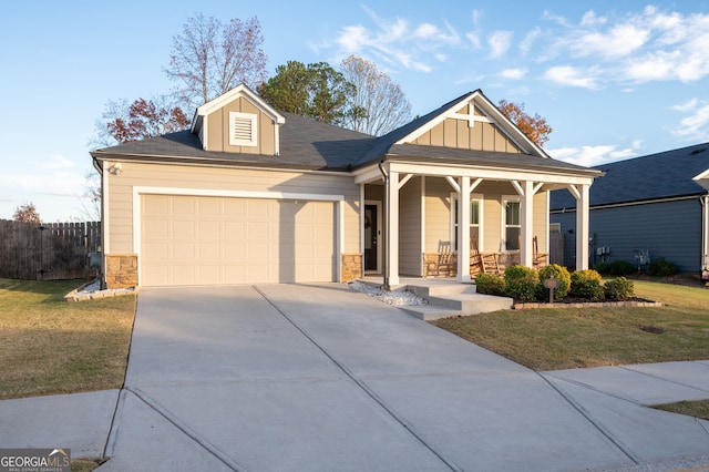 view of front of house with a front lawn, covered porch, and a garage