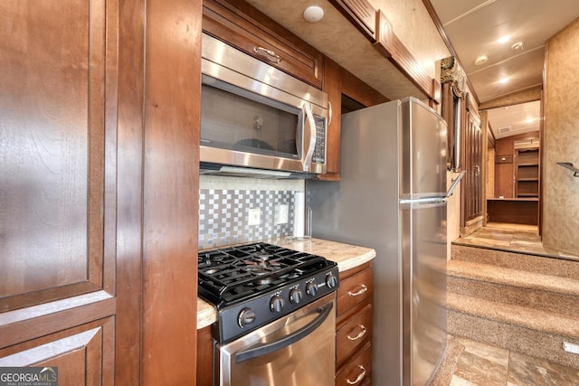 kitchen with stainless steel appliances, brown cabinetry, and decorative backsplash