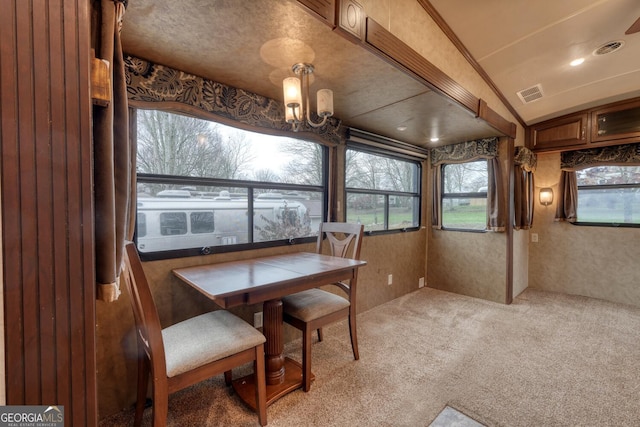 dining area featuring vaulted ceiling, carpet floors, and a chandelier