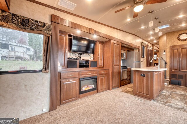 kitchen featuring stainless steel appliances, crown molding, a kitchen island with sink, and light colored carpet