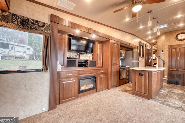 kitchen with crown molding, stainless steel appliances, light countertops, visible vents, and brown cabinetry