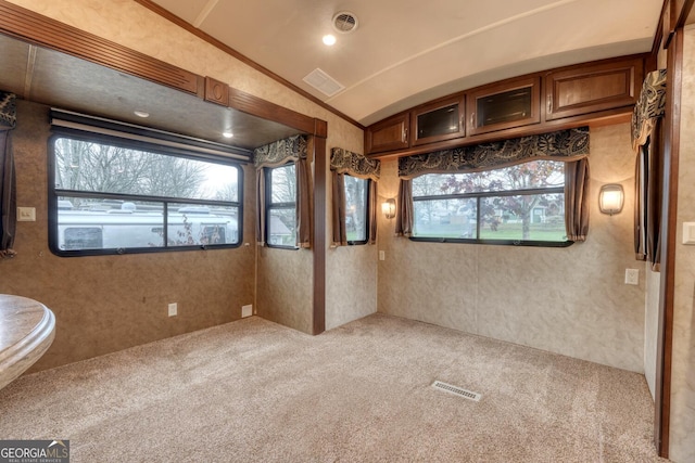 carpeted spare room with lofted ceiling and visible vents