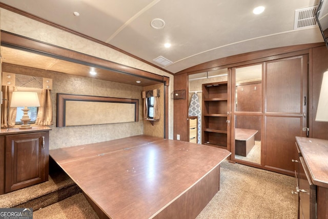 office area featuring ornamental molding, vaulted ceiling, and light carpet