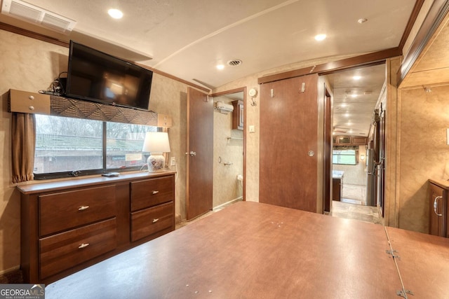 kitchen with a healthy amount of sunlight, a wall mounted AC, visible vents, and brown cabinets