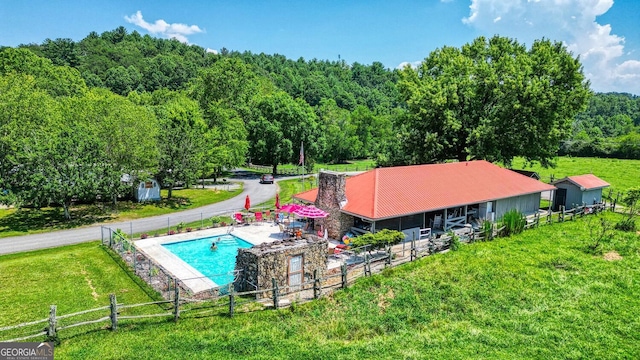 view of pool with a fenced in pool, an outbuilding, and an exterior structure