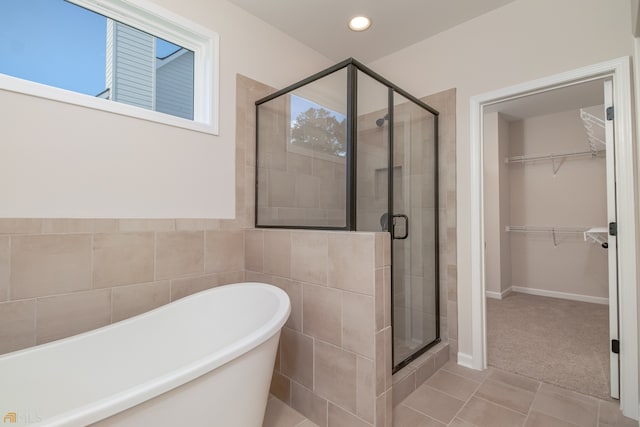 bathroom featuring tile patterned floors and separate shower and tub