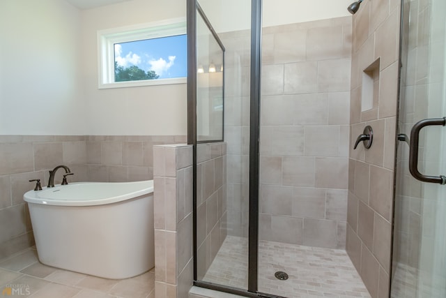 bathroom featuring tile patterned floors, plus walk in shower, and tile walls