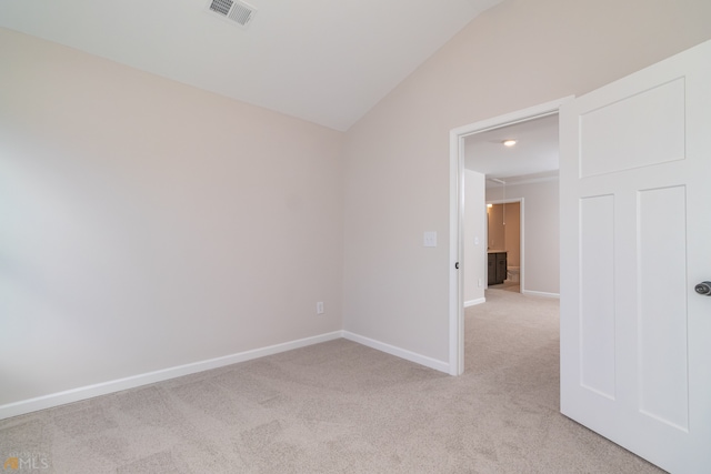 empty room featuring light carpet and lofted ceiling