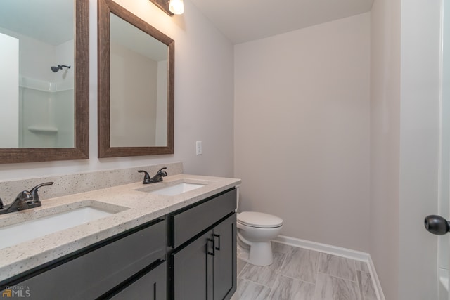 bathroom with walk in shower, vanity, and toilet