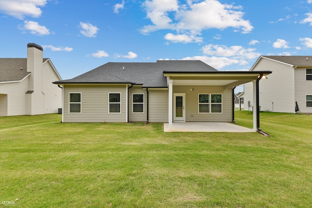 rear view of property featuring a lawn and a patio area