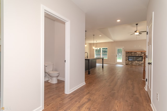 hallway with hardwood / wood-style floors and an inviting chandelier