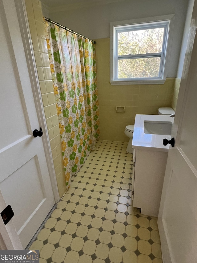 bathroom with a shower with curtain, vanity, toilet, and tile walls