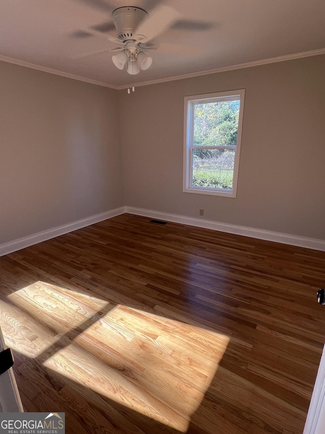 unfurnished room featuring ceiling fan, dark wood-type flooring, and ornamental molding