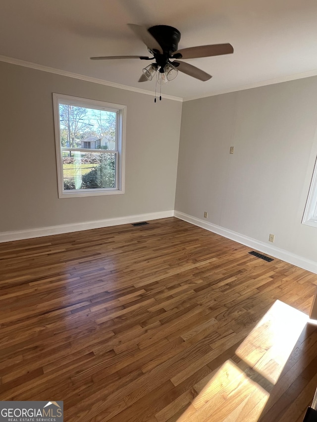 spare room with dark hardwood / wood-style floors, ceiling fan, and crown molding