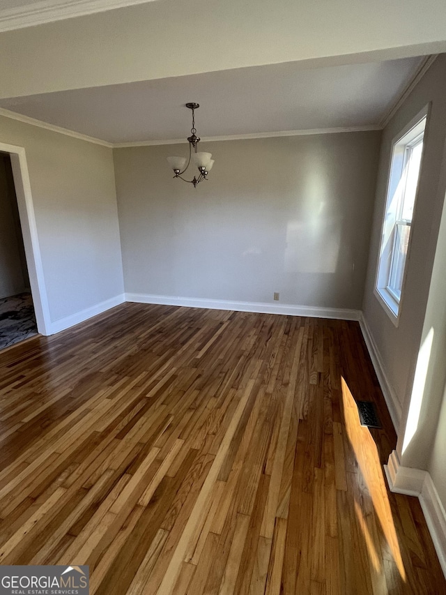 unfurnished dining area featuring ornamental molding, dark hardwood / wood-style floors, and an inviting chandelier