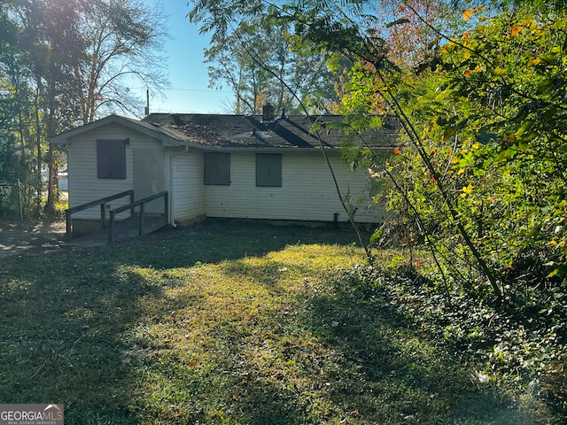 rear view of property featuring a lawn