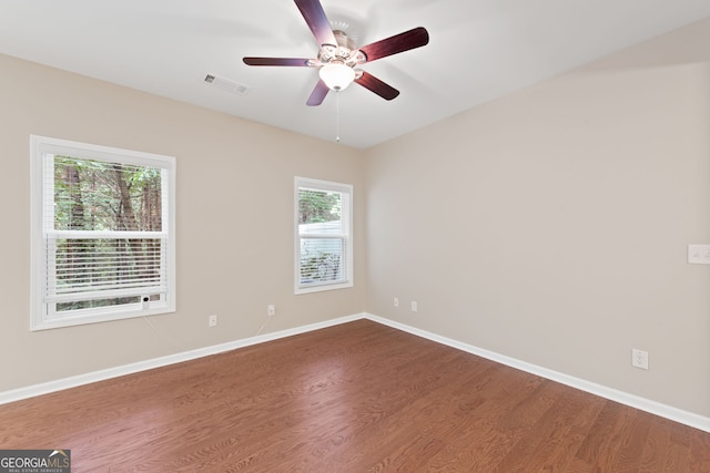 empty room with hardwood / wood-style flooring, plenty of natural light, and ceiling fan