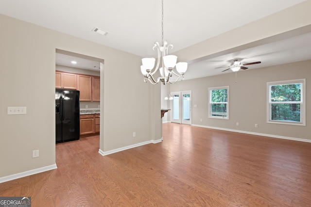 interior space with ceiling fan with notable chandelier and light hardwood / wood-style floors