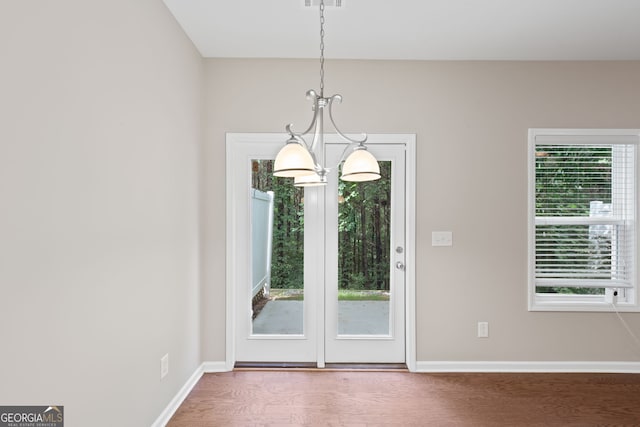 doorway to outside with hardwood / wood-style flooring and an inviting chandelier