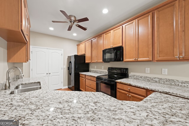 kitchen with ceiling fan, sink, black appliances, and light stone counters