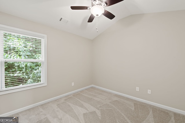 carpeted spare room featuring ceiling fan and lofted ceiling