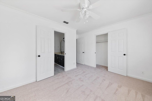 unfurnished bedroom with crown molding, light colored carpet, ceiling fan, and a closet