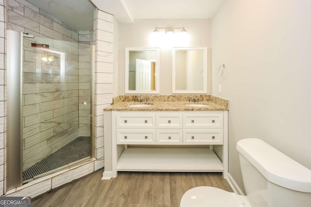 bathroom featuring vanity, hardwood / wood-style flooring, toilet, and an enclosed shower