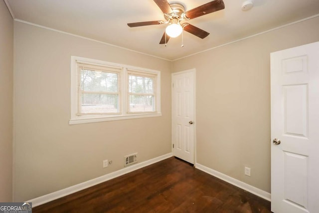 spare room featuring dark hardwood / wood-style floors, ceiling fan, and crown molding