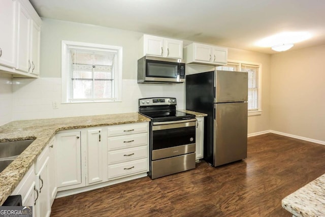 kitchen with stainless steel appliances, white cabinetry, a wealth of natural light, and dark wood-type flooring