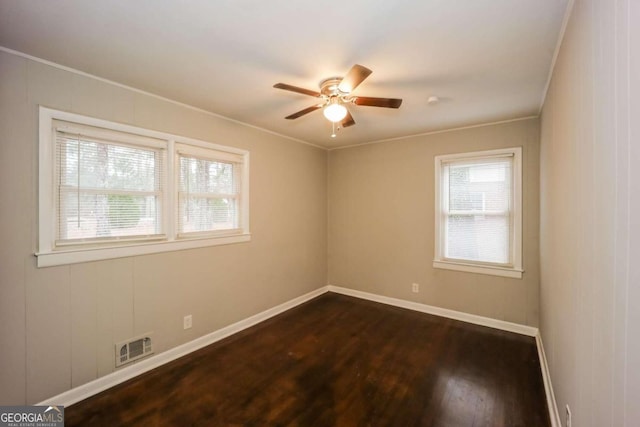 unfurnished room with ceiling fan, crown molding, and dark wood-type flooring