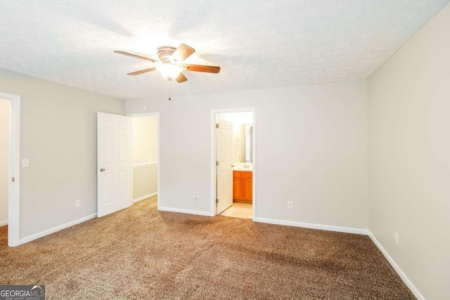 unfurnished bedroom with ensuite bath, ceiling fan, light carpet, and a textured ceiling