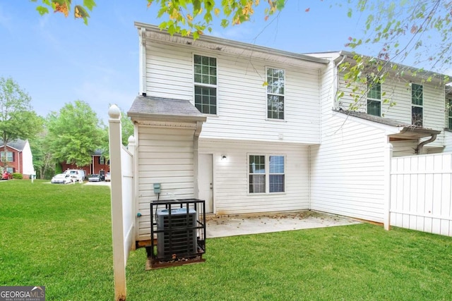 rear view of house featuring central AC unit, a patio area, and a lawn