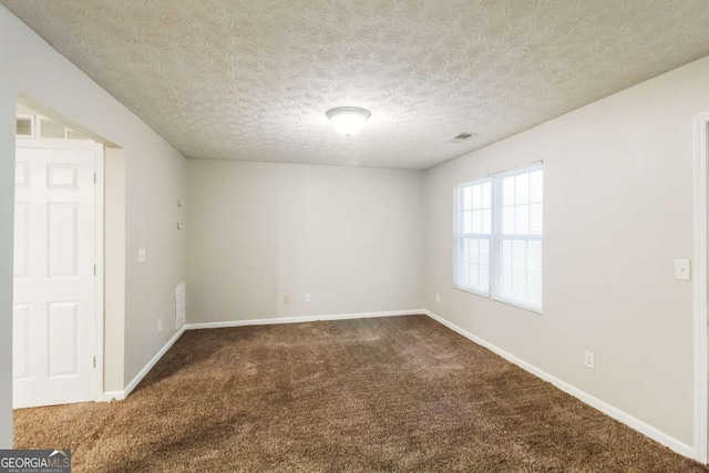 unfurnished room with carpet and a textured ceiling