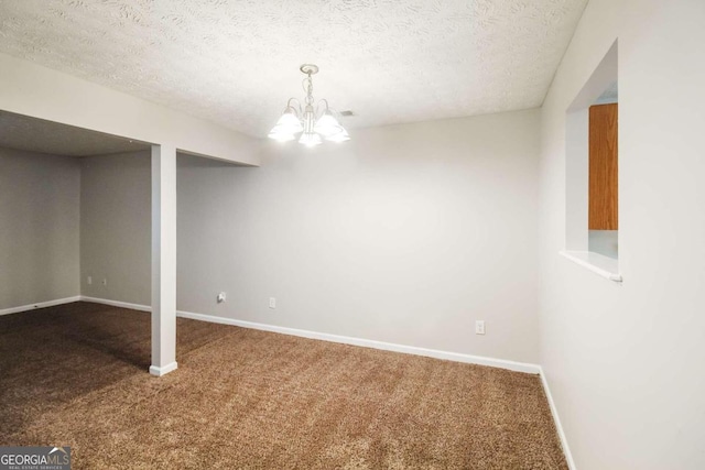 basement featuring carpet, a textured ceiling, and an inviting chandelier