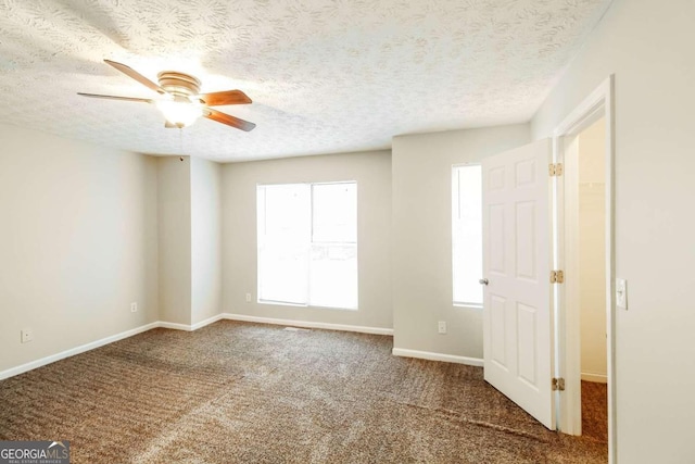 spare room with ceiling fan, carpet, a healthy amount of sunlight, and a textured ceiling