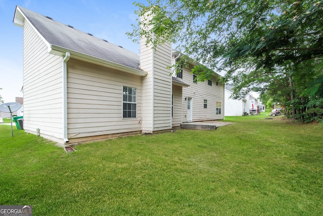 back of house with a lawn