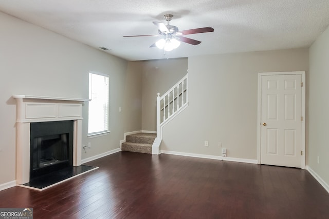 unfurnished living room with a textured ceiling, ceiling fan, and dark hardwood / wood-style floors