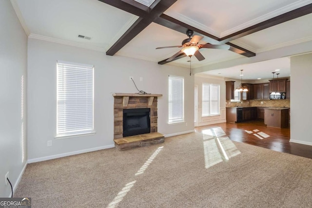 unfurnished living room with dark colored carpet, ceiling fan with notable chandelier, crown molding, and coffered ceiling