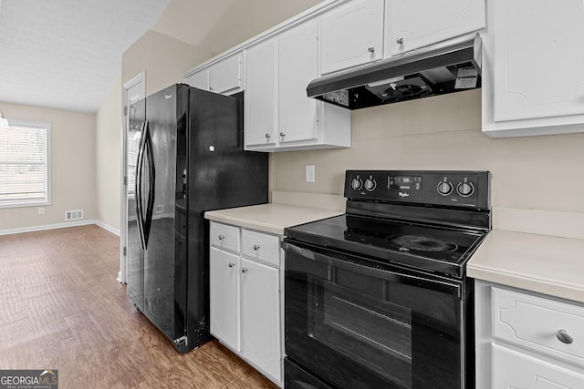 kitchen featuring white cabinets, a textured ceiling, light hardwood / wood-style flooring, and black appliances