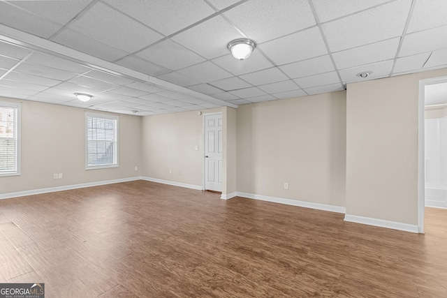 interior space featuring wood-type flooring and a drop ceiling