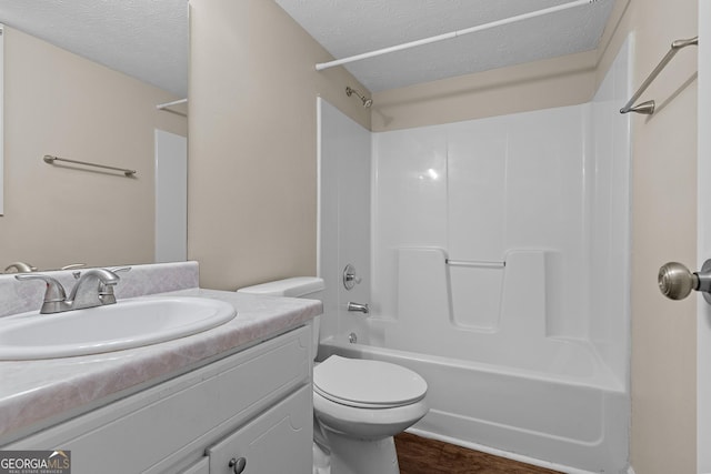 full bathroom featuring wood-type flooring, vanity, toilet, bathing tub / shower combination, and a textured ceiling