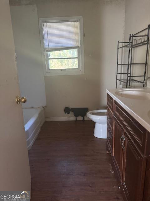 bathroom with hardwood / wood-style flooring, vanity, and toilet