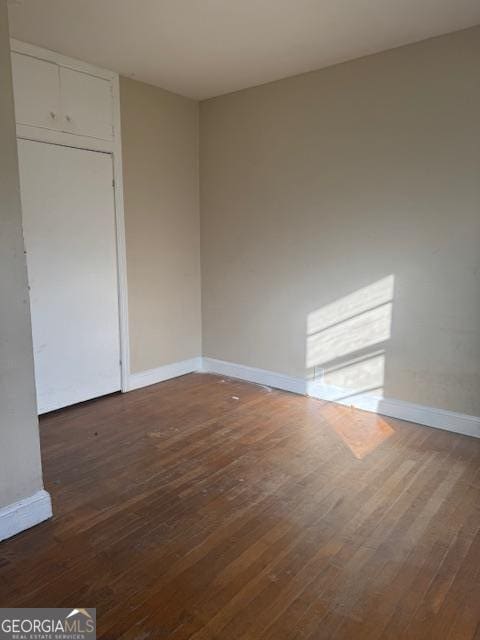 spare room with dark hardwood / wood-style flooring