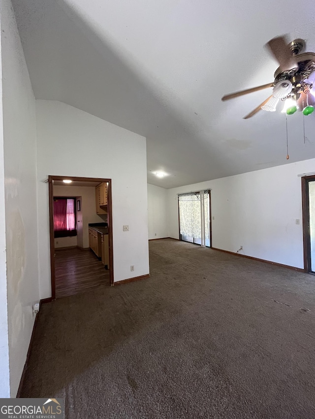 unfurnished living room featuring dark carpet, ceiling fan, and lofted ceiling