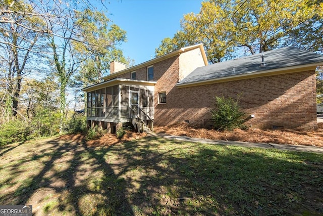 rear view of house with a sunroom and a yard