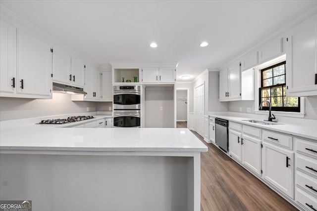 kitchen with appliances with stainless steel finishes, crown molding, dark wood-type flooring, sink, and white cabinets