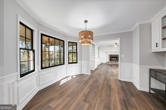 unfurnished dining area featuring dark hardwood / wood-style flooring and crown molding