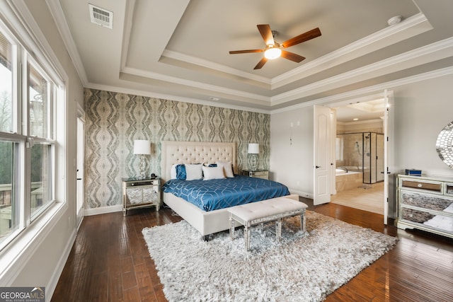 bedroom with crown molding, a tray ceiling, and dark wood-type flooring