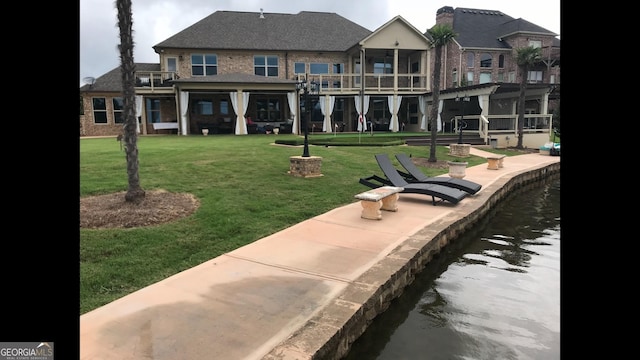 view of property's community with a water view and a lawn